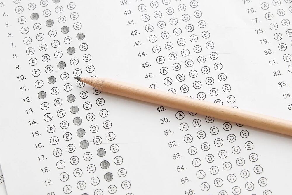 Answer sheet with a wooden pencil resting on top